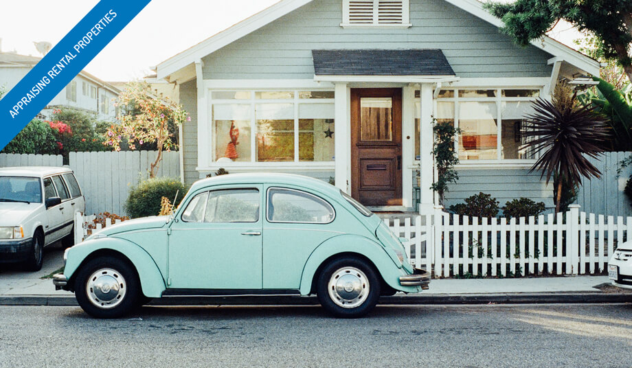 Light blue rental house with white picket fence and matching VW Bug